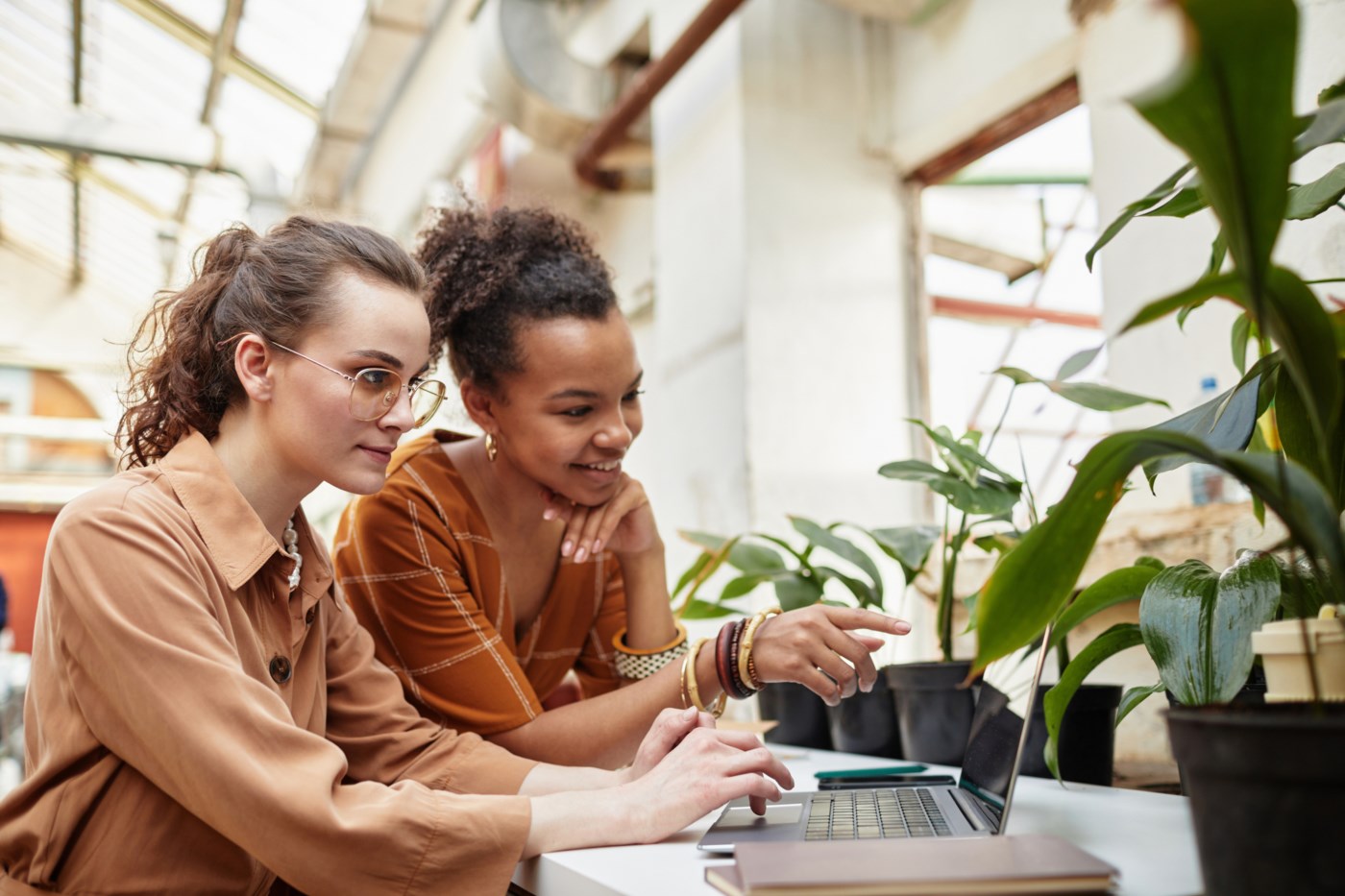 to jenter sitter ved pc-en og diskuterer