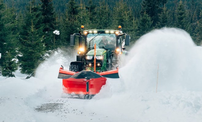 Traktor rydder snø